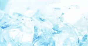 Close-up of crystalline ice cubes, reflecting light in shades of blue and white, creating a cool, refreshing ambiance.